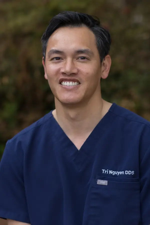 Portrait of Dr. Tri Nguyen in navy scrubs